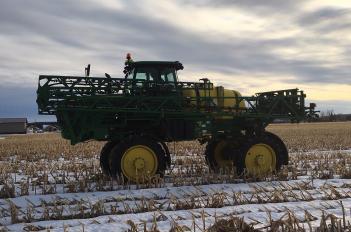 sprayer in snowy corn stubble